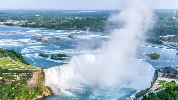 Una cascada fluye frente a un paisaje verde exuberante cerca de la Nakusp Secondary School.