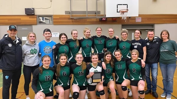 Un grupo de estudiantes de la Nanaimo District Secondary School posando en el gimnasio frente a una canasta de baloncesto.