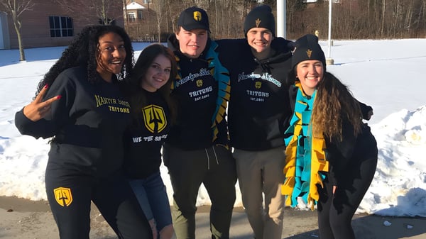 Un grupo de alumnas y alumnos de la Nantyr Shores Secondary School está junto con sudaderas negras en la nieve.