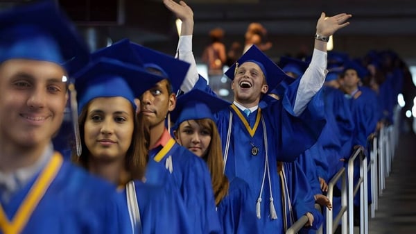 Un grupo de graduados de la Napanee District Secondary School celebra en togas azules su graduación.