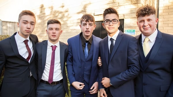 Un grupo de cinco estudiantes de la Napier Boys High School está frente a un edificio de ladrillo.