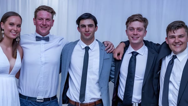 Cinco personas posan juntas frente a un fondo blanco en el campus de la Naracoorte High School.