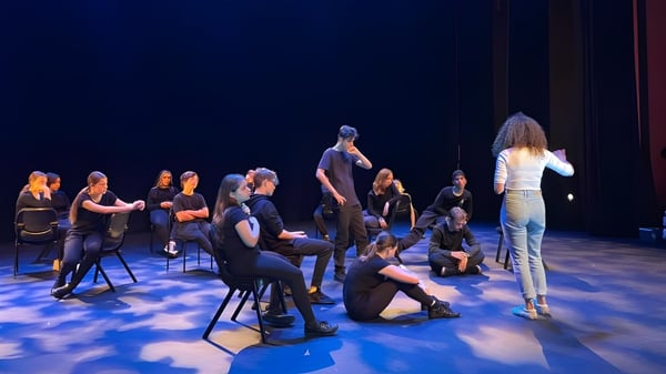 Estudiantes de la Nepean High School se reúnen en un escenario con iluminación azul.