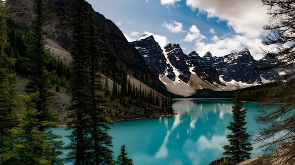 Un tranquilo lago turquesa rodeado de montañas nevadas y bosques perennes cerca de la Nepean High School.
