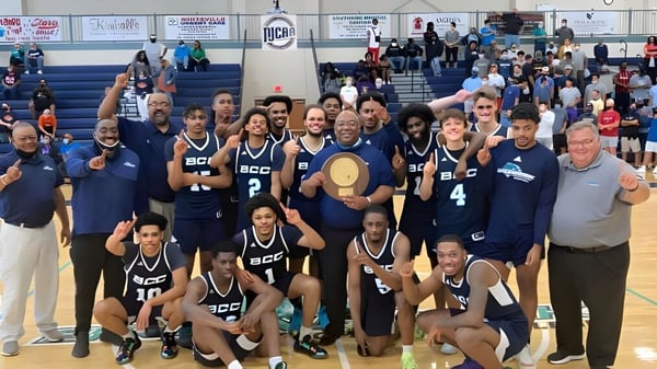 El equipo de baloncesto del New Brunswick Community College posa junto en el gimnasio.