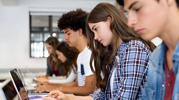 Estudiantes de la Niskayuna High School se concentran en el aula en sus computadoras portátiles.