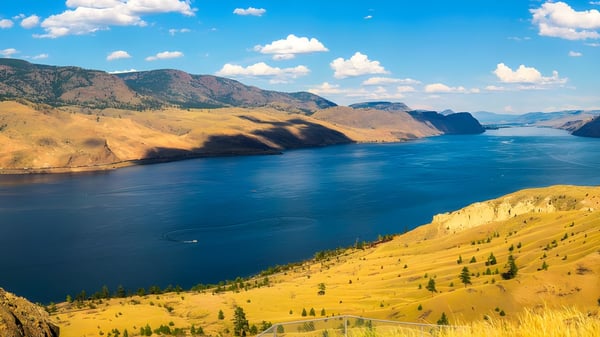 Un lago tranquilo con montañas y follaje otoñal se puede ver cerca de la NorKam Secondary School.