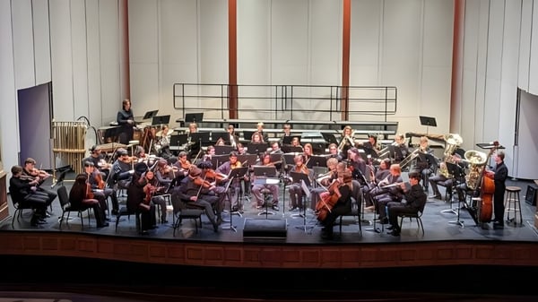 Una gran orquesta de la North Cross School toca en un escenario con varios instrumentos.