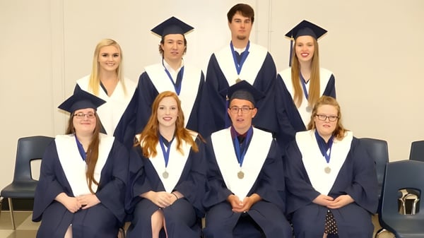 Graduadas y graduados de la North Dundas District High School en vestimenta académica posan para una foto grupal.