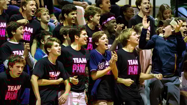 Un grupo de estudiantes de la North Shore Country Day School celebra juntos en camisetas de equipo durante un evento.