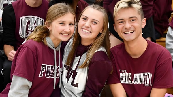 Tres estudiantes de la Northeastern Wisconsin Lutheran High School sonríen juntas en un entorno escolar.