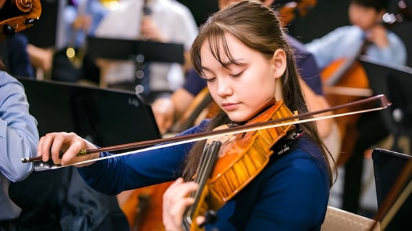 Una alumna de la Northern Academy toca concentrada el violín durante una actuación musical.