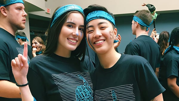 Dos estudiantes con cintas azules posan juntas en un interior de la Northview Heights Secondary School.