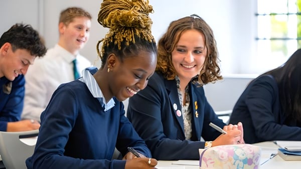 Un grupo de estudiantes trabaja juntos en mesas en el aula de la Norwich School.