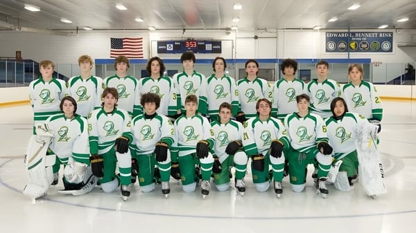 Un grupo de jóvenes jugadoras y jugadores de hockey posan en la pista de hielo en el campus de la Notre Dame de la Baie Academy.