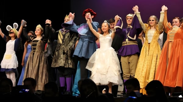 Un grupo de estudiantes de la Notre Dame de la Baie Academy presenta una obra de teatro en un escenario.