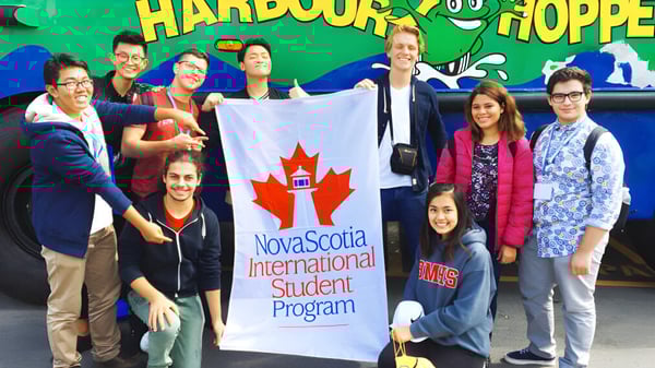 Estudiantes frente a un colorido mural con la inscripción Harbour Hopper en el campus del Nova Scotia International Student Program.