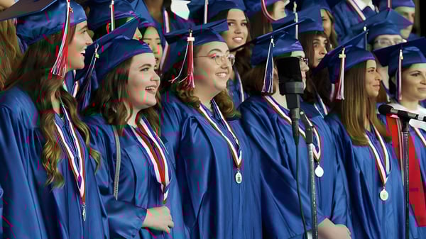 Los graduados de la Oakridge Secondary School están juntos en túnicas azules durante una ceremonia de graduación.