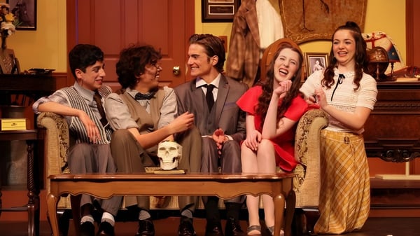 Un grupo de estudiantes de la Oaks Christian School conversa en una sala acogedora con decoraciones vintage.