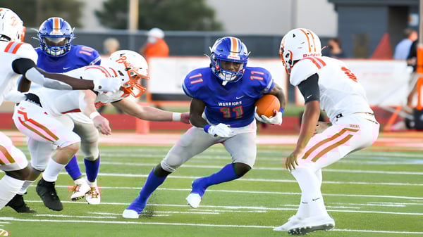 Estudiantes juegan un partido de fútbol americano en el campo de las Orange County Public Schools.