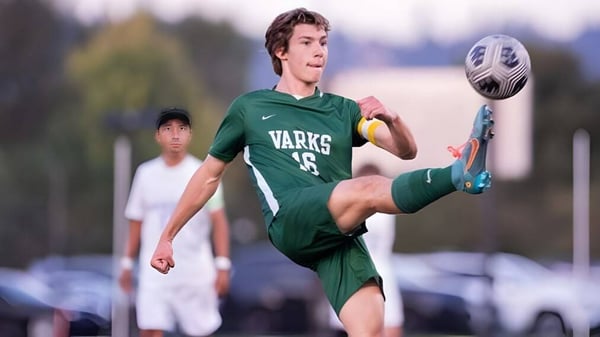 Un estudiante de la Oregon Episcopal School patea un balón de fútbol en el campo durante un partido.