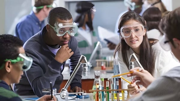 Estudiantes de la Osgoode Township High School realizan un experimento en el laboratorio con gafas de protección.