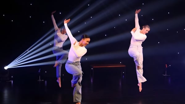 Dos bailarines realizan una actuación en el escenario de Oundle School frente a un fondo iluminado por estrellas.
