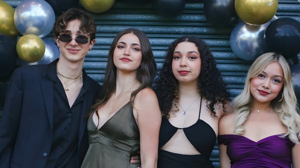 Cuatro personas, dos mujeres y dos hombres, posan frente a globos de colores en el Oxford Sixth Form College.