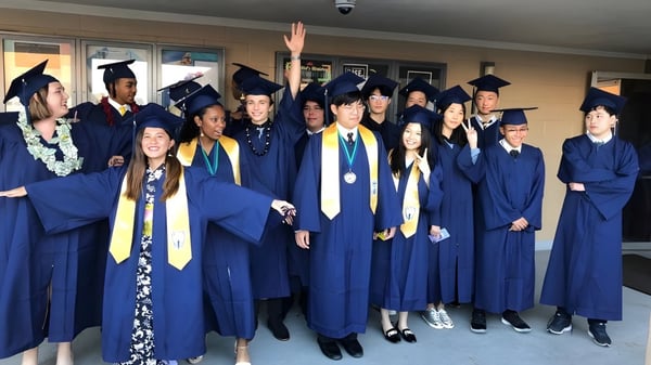 Un grupo de graduados de la Pacific Lutheran High School celebra juntos su graduación en el pasillo.