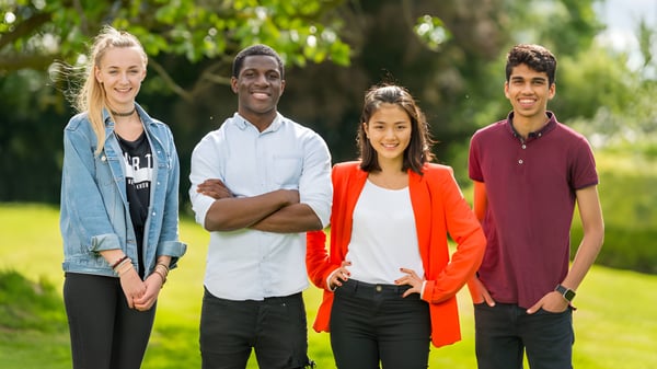 Un grupo de cuatro estudiantes está juntos en el área verde exterior del Padworth College.