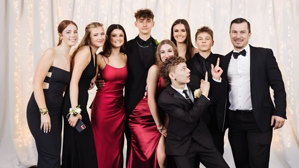 Un grupo de personas en ropa formal posan frente a una cortina en el campus del Pakuranga College.