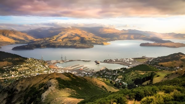 Toma aérea del paisaje con montañas y un lago cerca del Pakuranga College al atardecer.