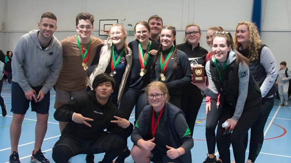 Un grupo de estudiantes con medallas posan en una instalación deportiva de la Palmerstown Community School.