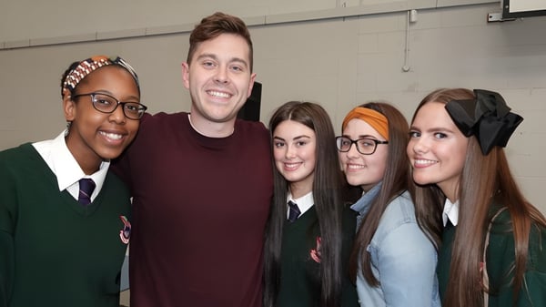Cinco estudiantes posan juntos en la Palmerstown Community School frente a una pared sencilla.