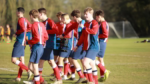 Un grupo de jóvenes futbolistas está junto en el campo deportivo del Pangbourne College.