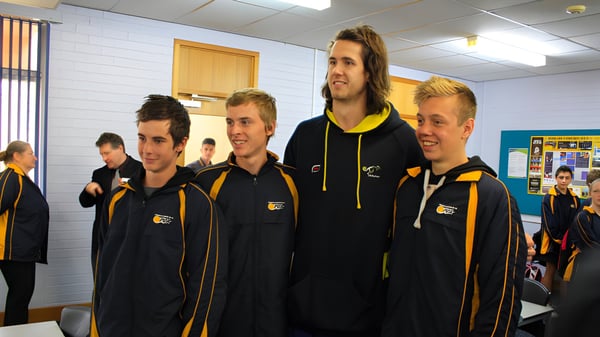 Un grupo de estudiantes de la Paralowie R-12 School está de pie en uniformes negros y amarillos en una instalación deportiva.