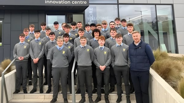 Estudiantes de la Patrician High School están en uniforme escolar frente al edificio del Centro de Innovación.