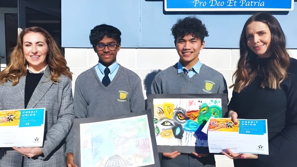 Cuatro estudiantes de la Patrician High School presentan sus obras de arte en el edificio escolar.
