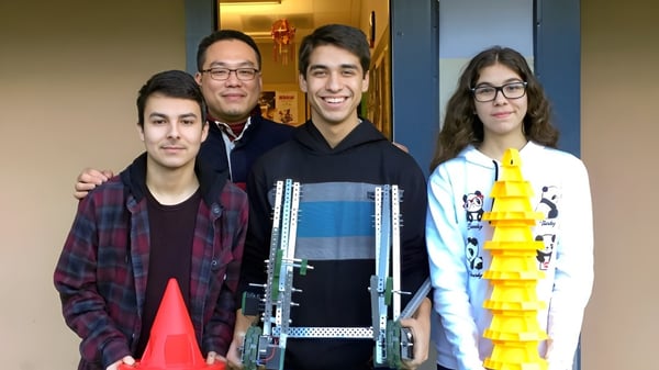 Un grupo de cuatro estudiantes está con Pender Harbour Secondary en el pasillo y sonríe.