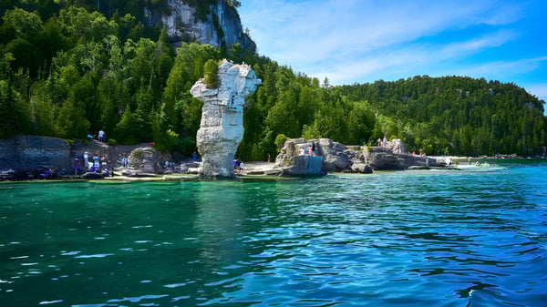 Un lago idílico rodeado de densos bosques y rocas cerca del Pickering College.