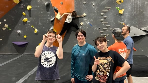 Estudiantes están frente a la pared de escalada en el campus de la École secondaire publique Pierre de Blois.