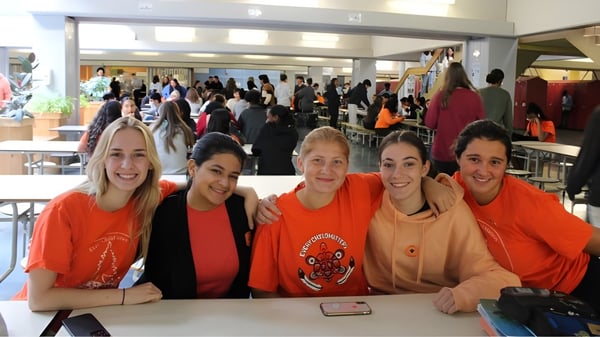 Cinco estudiantes de la Pierrefonds Community High School posan juntas en una situación interior animada.