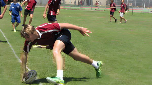 Una jugadora de fútbol de la Pittwater High School aparece en el campo para alcanzar el balón.