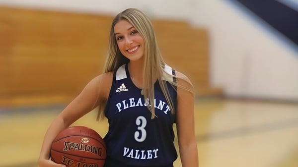 Una estudiante de la Pleasant Valley High School está con un baloncesto en el gimnasio.