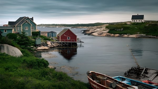 Vista de una escena costera con casas coloridas y un pequeño bote frente a la Polyvalente Roland-Pépin.