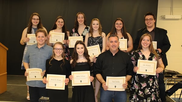 Las estudiantes y estudiantes de la Polyvalente W.-A.-Losier sostienen certificados y posan para una foto grupal en un entorno formal.