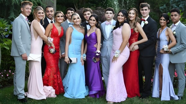 Un grupo de estudiantes de la Portmarnock Community School posan juntos con ropa formal en el jardín.