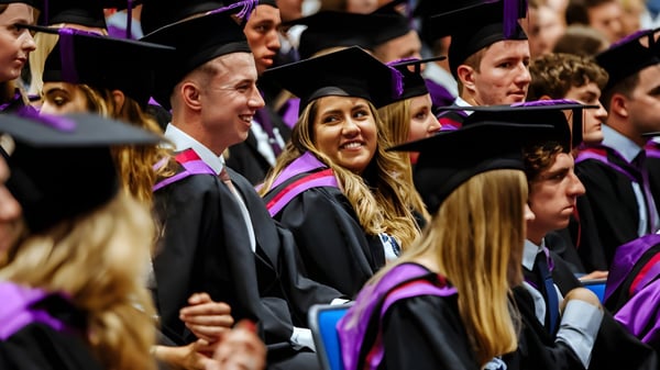 Graduadas y graduados del Portsmouth College en coloridos trajes académicos se reúnen para celebrar.