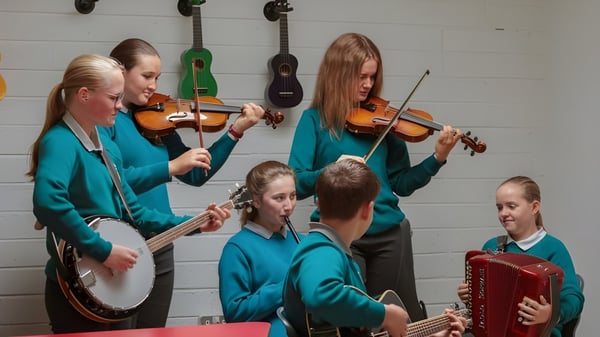 Un grupo de estudiantes toca diferentes instrumentos musicales en el aula de música del Portumna Community College.