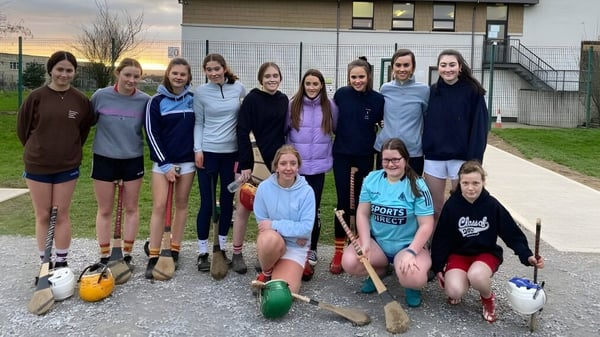 Un grupo de alumnas posa con equipo deportivo afuera de un edificio en el campus de la Presentation Secondary School en Cork.